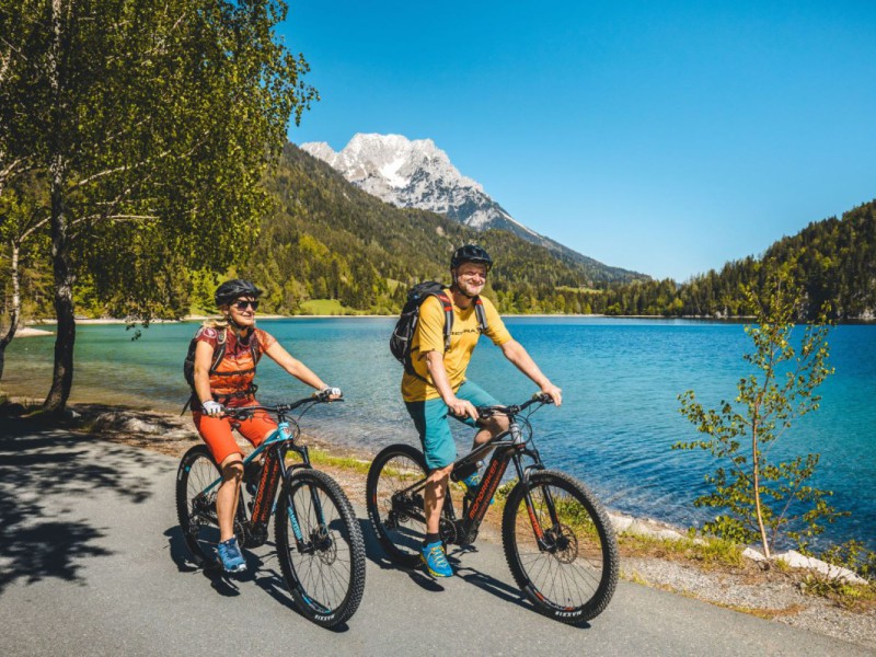 Mountainbikers die langs een groot meer fietsen